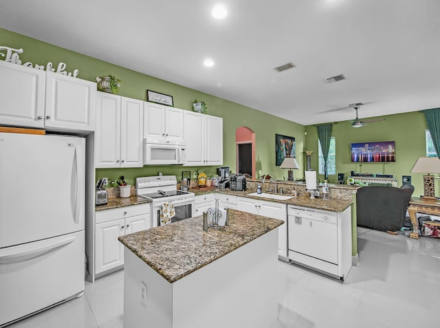 1081 SW Jacqueline Ave, Port Saint Lucie, FL 34953 - kitchen featuring white appliances, a peninsula, stone countertops, white cabinetry, and open floor plan