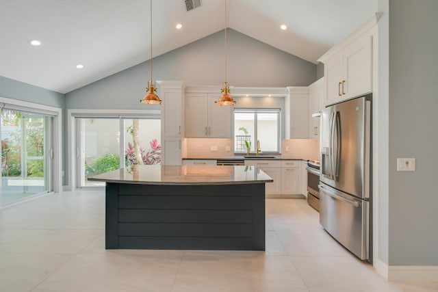 438 River Edge Rd, Jupiter, FL 33477 - kitchen featuring stainless steel appliances, a sink, backsplash, white cabinets, and a center island