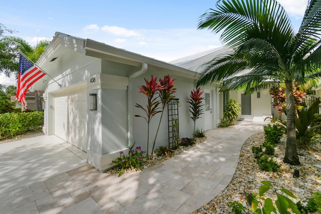438 River Edge Rd, Jupiter, FL 33477 - view of property exterior featuring a garage, driveway, and stucco siding