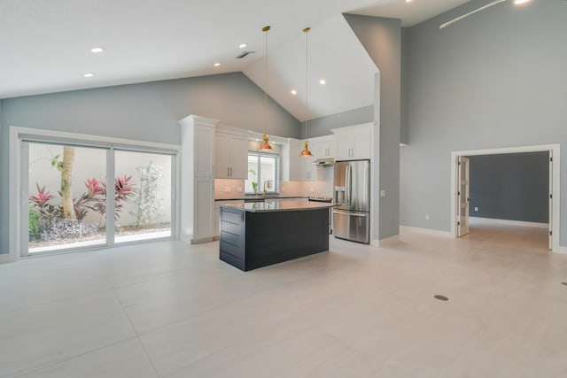 438 River Edge Rd, Jupiter, FL 33477 - kitchen featuring stainless steel refrigerator with ice dispenser, high vaulted ceiling, white cabinets, a kitchen island, and under cabinet range hood
