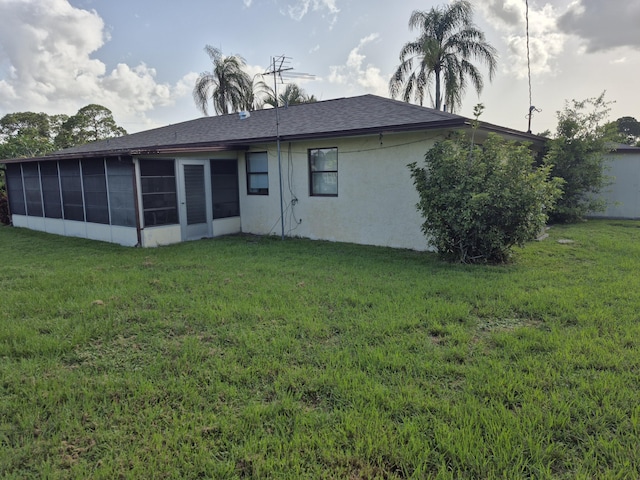 2897 SW Ortega St, Port Saint Lucie, FL 34953 - back of property with a sunroom, a yard, stucco siding, and a shingled roof