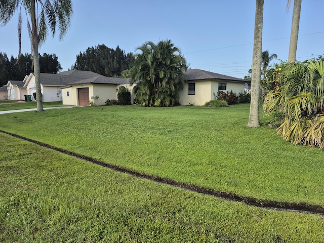 2897 SW Ortega St, Port Saint Lucie, FL 34953 - view of green lawn with an attached garage