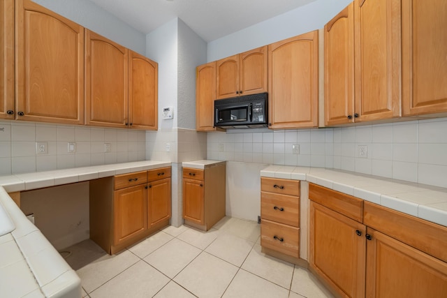 5554 Boynton Gardens Dr, Boynton Beach, FL 33437 - kitchen featuring black microwave, decorative backsplash, and light tile patterned flooring