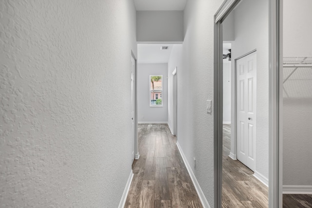5554 Boynton Gardens Dr, Boynton Beach, FL 33437 - hallway featuring a textured wall, wood finished floors, and baseboards
