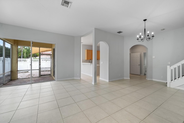 5554 Boynton Gardens Dr, Boynton Beach, FL 33437 - unfurnished room featuring arched walkways, light tile patterned flooring, a chandelier, and baseboards