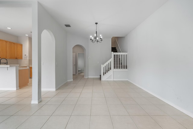5554 Boynton Gardens Dr, Boynton Beach, FL 33437 - spare room featuring arched walkways, stairway, a chandelier, recessed lighting, and light tile patterned flooring