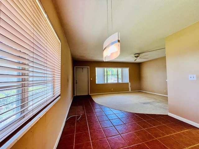 80 Norwich D, West Palm Beach, FL 33417 - spare room featuring dark tile patterned floors, a ceiling fan, and dark carpet