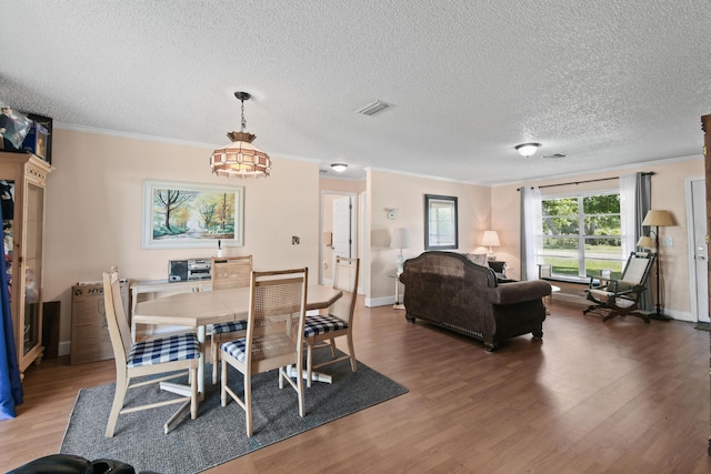 6506 Kings Hwy, Fort Pierce, FL 34951 - dining room featuring ornamental molding, wood finished floors, baseboards, and a textured ceiling