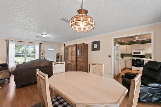 6506 Kings Hwy, Fort Pierce, FL 34951 - dining area featuring a textured ceiling, light wood-style flooring, ornamental molding, and ceiling fan