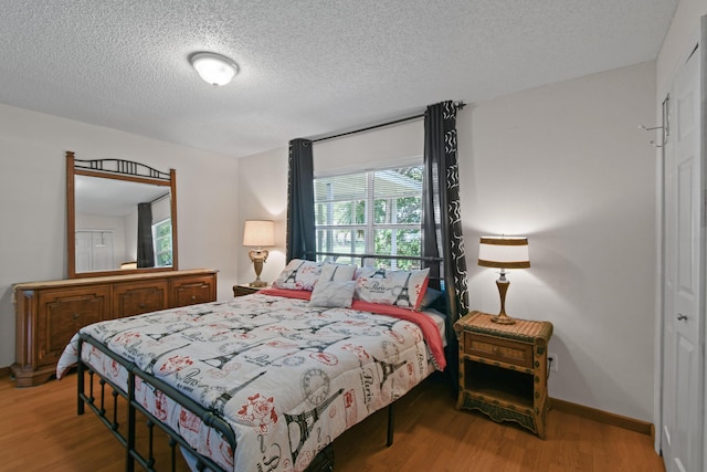 6506 Kings Hwy, Fort Pierce, FL 34951 - bedroom featuring wood finished floors, a textured ceiling, a closet, and baseboards