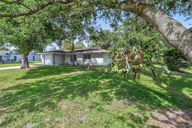 6506 Kings Hwy, Fort Pierce, FL 34951 - view of front of home with an attached garage, a front yard, stucco siding, and concrete driveway