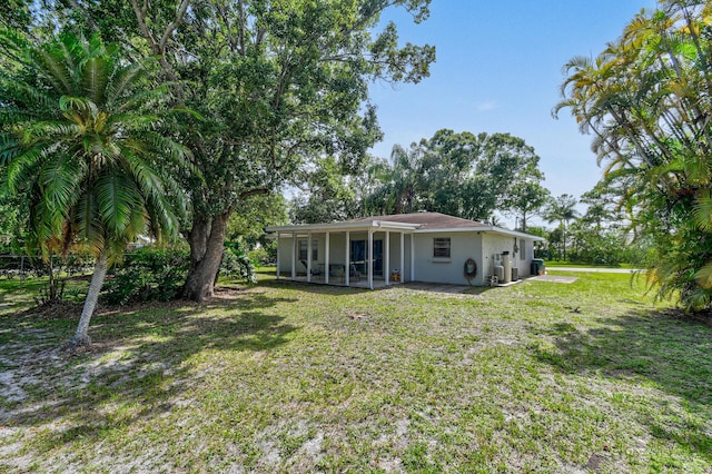 6506 Kings Hwy, Fort Pierce, FL 34951 - rear view of property featuring a sunroom, a yard, and stucco siding