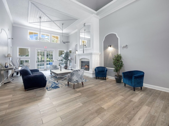 815 W Boynton Beach Blvd Unit 15-203, Boynton Beach, FL 33426 - living area featuring a glass covered fireplace, wood finished floors, ornamental molding, baseboards, and a towering ceiling