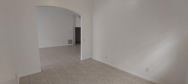 456 NW Marsala Ter, Port Saint Lucie, FL 34986 - spare room featuring arched walkways, light tile patterned floors, and baseboards