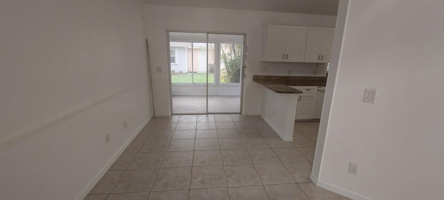 456 NW Marsala Ter, Port Saint Lucie, FL 34986 - kitchen with white cabinets, light tile patterned flooring, baseboards, and dark countertops