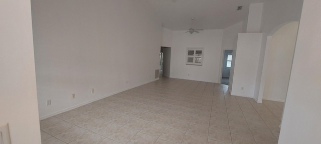 456 NW Marsala Ter, Port Saint Lucie, FL 34986 - empty room with high vaulted ceiling, arched walkways, light tile patterned floors, a ceiling fan, and baseboards