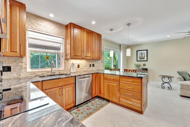 519 SE Brookside Ter, Port Saint Lucie, FL 34983 - kitchen featuring dishwasher, a sink, a peninsula, backsplash, and dark stone counters