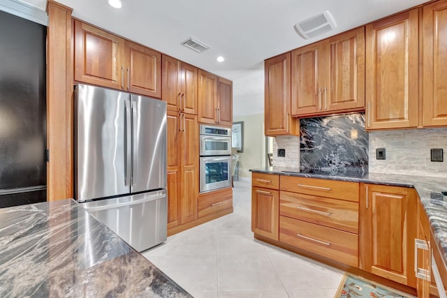 519 SE Brookside Ter, Port Saint Lucie, FL 34983 - kitchen with stainless steel appliances, tasteful backsplash, light tile patterned floors, dark stone counters, and recessed lighting