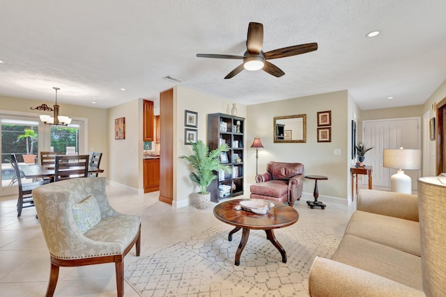 519 SE Brookside Ter, Port Saint Lucie, FL 34983 - living area featuring a ceiling fan, a chandelier, a textured ceiling, baseboards, and light tile patterned flooring