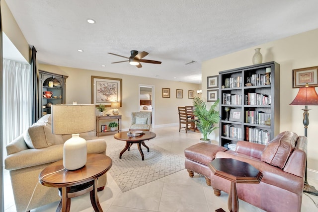 519 SE Brookside Ter, Port Saint Lucie, FL 34983 - living room featuring a ceiling fan, a textured ceiling, baseboards, and recessed lighting