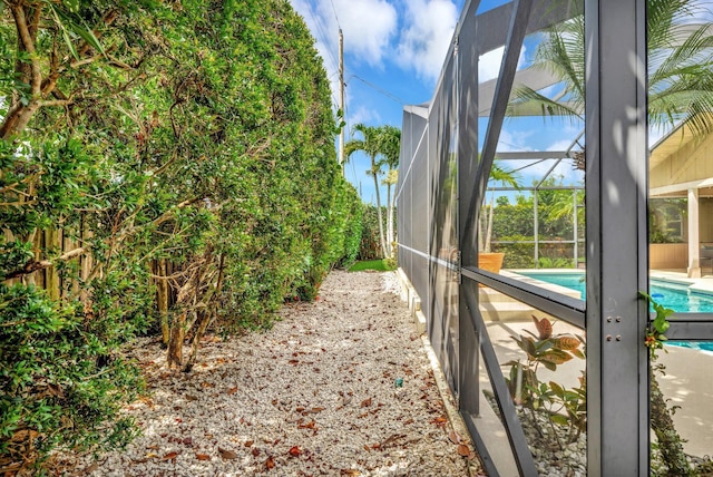 519 SE Brookside Ter, Port Saint Lucie, FL 34983 - view of side of property with an outdoor pool, a fenced backyard, and glass enclosure