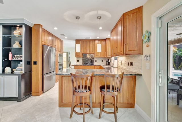 519 SE Brookside Ter, Port Saint Lucie, FL 34983 - kitchen featuring stainless steel appliances, a sink, a peninsula, decorative backsplash, and stone counters