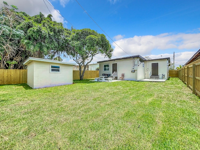 903 21st St, West Palm Beach, FL 33407 - back of property with stucco siding, a patio area, and an outdoor structure