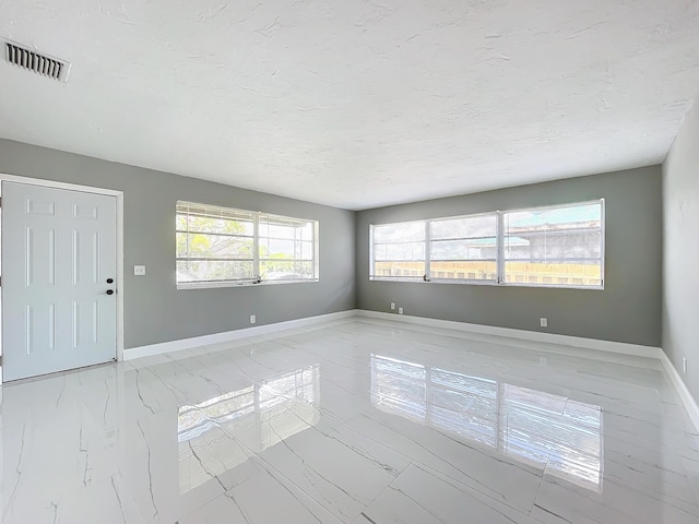 903 21st St, West Palm Beach, FL 33407 - spare room with baseboards, light marble finish floors, and a textured ceiling