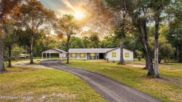 2318 Old Samsula Rd, Port Orange, FL 32128 - view of front of home featuring a yard, driveway, a detached carport, and view of wooded area