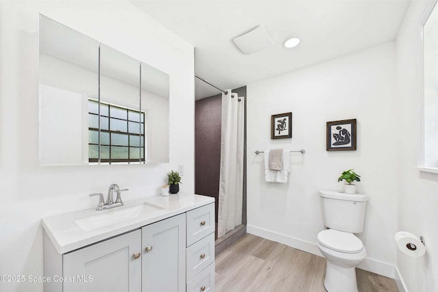 2318 Old Samsula Rd, Port Orange, FL 32128 - bathroom with toilet, vanity, wood finished floors, and baseboards
