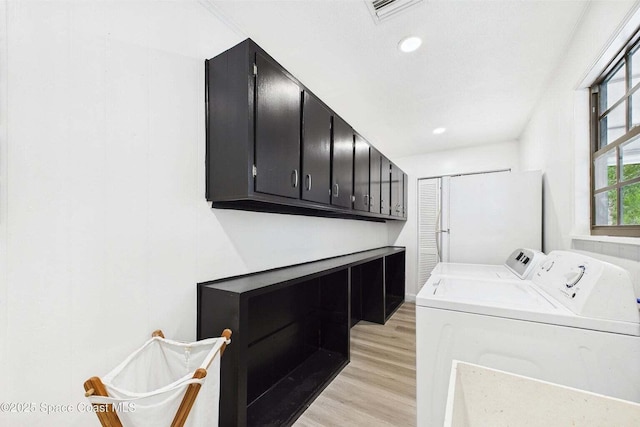 2318 Old Samsula Rd, Port Orange, FL 32128 - laundry area with washing machine and clothes dryer, cabinet space, light wood-type flooring, and recessed lighting
