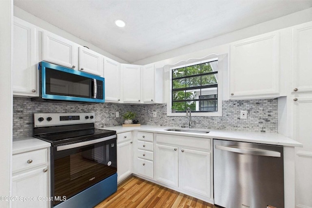 2318 Old Samsula Rd, Port Orange, FL 32128 - kitchen with appliances with stainless steel finishes, a sink, light countertops, decorative backsplash, and white cabinets