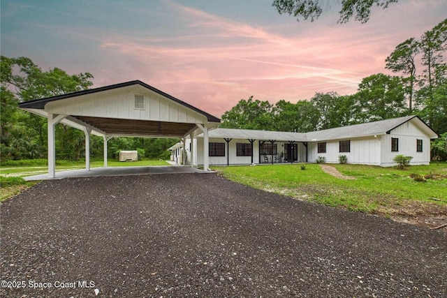 2318 Old Samsula Rd, Port Orange, FL 32128 - view of front of home with gravel driveway, a yard, and board and batten siding
