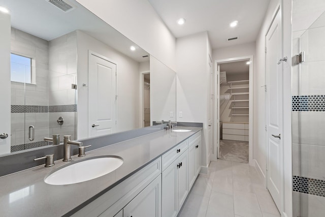 6825 Pointe Of Woods Dr, West Palm Beach, FL 33413 - full bathroom with double vanity, a shower stall, a walk in closet, recessed lighting, and tile patterned flooring