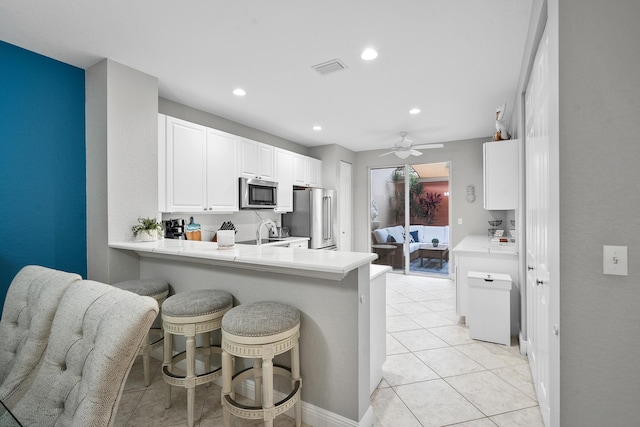 2381 SW Island Creek Trl, Palm City, FL 34990 - kitchen with appliances with stainless steel finishes, a kitchen breakfast bar, light countertops, ceiling fan, and a peninsula