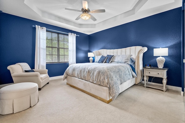 2381 SW Island Creek Trl, Palm City, FL 34990 - bedroom featuring a tray ceiling, baseboards, a textured wall, carpet flooring, and ceiling fan