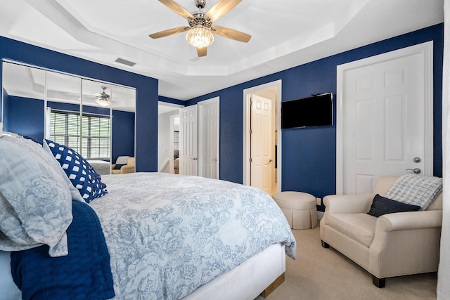 2381 SW Island Creek Trl, Palm City, FL 34990 - carpeted bedroom featuring a tray ceiling and ceiling fan