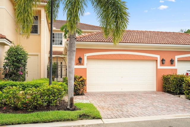 2381 SW Island Creek Trl, Palm City, FL 34990 - view of front of property with decorative driveway, a tile roof, stucco siding, and an attached garage