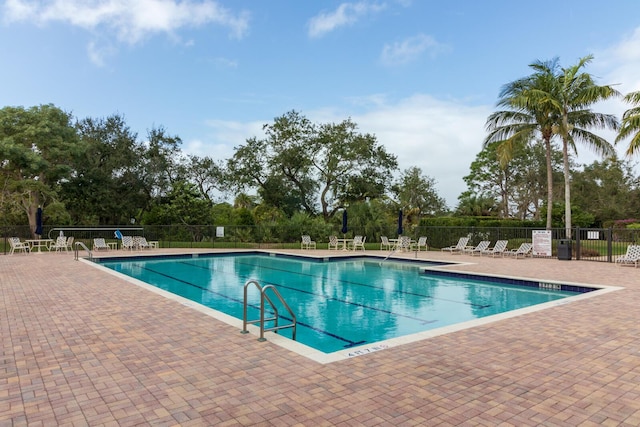 2381 SW Island Creek Trl, Palm City, FL 34990 - community pool with a patio and view of wooded area