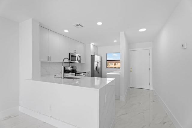7420 S Ocean Dr Unit 314, Jensen Beach, FL 34957 - kitchen with appliances with stainless steel finishes, light marble finish flooring, light countertops, recessed lighting, and white cabinets