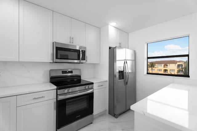 7420 S Ocean Dr Unit 314, Jensen Beach, FL 34957 - kitchen featuring appliances with stainless steel finishes, light marble finish flooring, white cabinets, light countertops, and recessed lighting