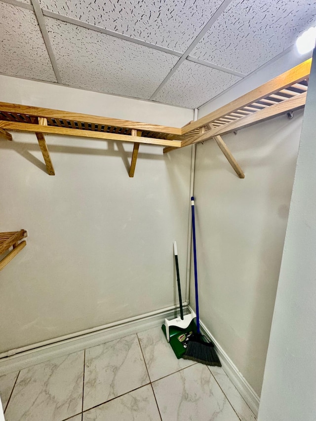 200 Village Green Cir E Unit 102, Palm Springs, FL 33461 - walk in closet featuring a paneled ceiling and marble finish flooring