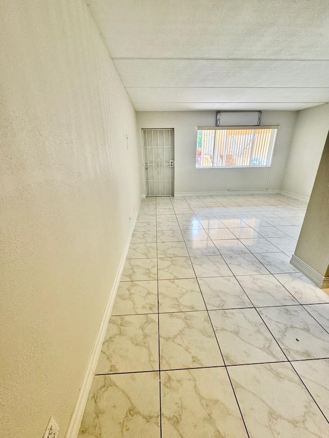 200 Village Green Cir E Unit 102, Palm Springs, FL 33461 - unfurnished room with marble look tiles and baseboards