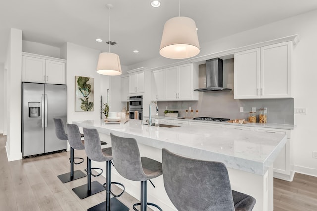 13330 Machiavelli Way, Palm Beach Gardens, FL 33418 - kitchen featuring appliances with stainless steel finishes, wall chimney exhaust hood, a sink, light wood-style floors, and recessed lighting