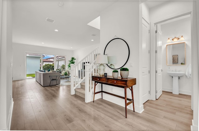 13330 Machiavelli Way, Palm Beach Gardens, FL 33418 - corridor with light wood-style flooring, stairs, baseboards, a sink, and recessed lighting
