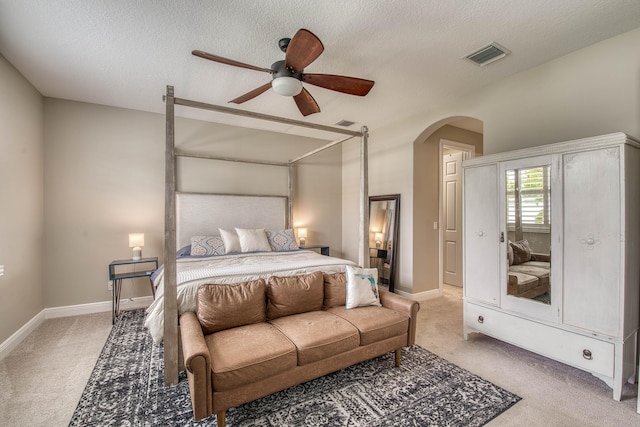 10295 SW Waterway Ln, Port Saint Lucie, FL 34987 - bedroom featuring arched walkways, light colored carpet, a textured ceiling, and ceiling fan