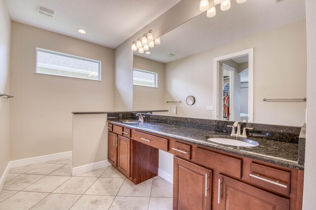 10295 SW Waterway Ln, Port Saint Lucie, FL 34987 - bathroom featuring double vanity, tile patterned flooring, tiled shower, and a textured ceiling