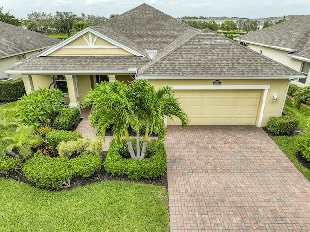 10295 SW Waterway Ln, Port Saint Lucie, FL 34987 - view of front of property featuring a shingled roof, stucco siding, an attached garage, and decorative driveway