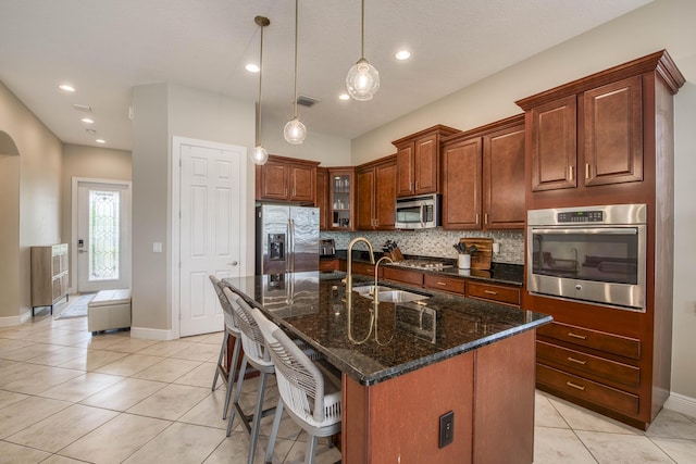 10295 SW Waterway Ln, Port Saint Lucie, FL 34987 - kitchen with appliances with stainless steel finishes, light tile patterned flooring, tasteful backsplash, a breakfast bar, and hanging light fixtures
