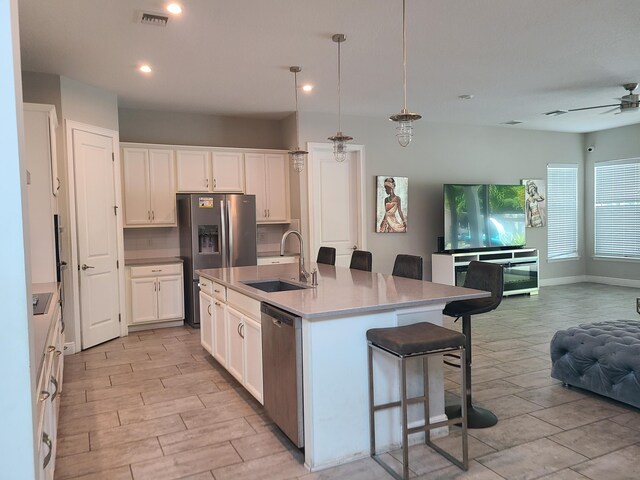 4019 Cascade Falls Cir, Lake Worth, FL 33467 - kitchen with stainless steel appliances, open floor plan, a kitchen bar, ceiling fan, and white cabinetry